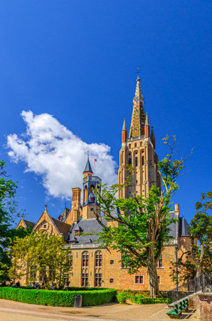 Roman Catholic Church of Our Lady Gothic style building with tower and cross on spire, Onze-Lieve-Vrouwekerk, Brugge old town, Bruges city historical centre, vertical view, Flemish Region, Belgiumの写真素材