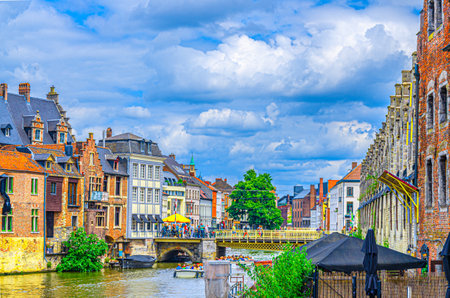 Old buildings houses on bank of Lys Leie river and Vleeshuisbrug bridge across water canal in Ghent historical city centre, Gent old town, East Flanders province, Flemish Region, Belgiumの写真素材