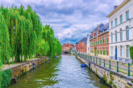 Ghent cityscape, embankment promenade and old brick buildings on bank of Lieve water canal, Ghent historical city center Princes Court district, Gent old town, East Flanders province, Belgiumの写真素材