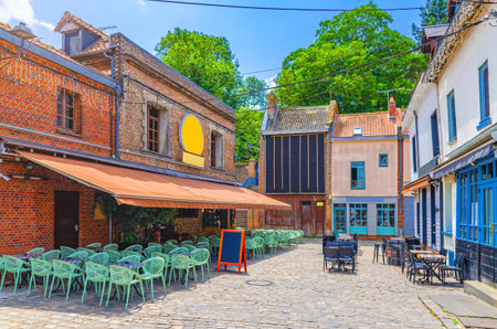 Street restaurants with tables and chairs near old brick buildings in Amiens historical city centre, cozy cafe in old town Saint-Leu quarter, Somme department, Hauts-de-France Region, Northern Franceの写真素材