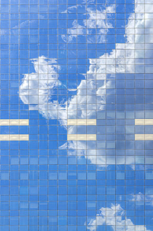 South Tower skyscraper modernism architecture style, modern high-rise office building, abstract details of facade glass curtain wall cells reflecting white clouds in blue sky, Brussels city, Belgiumの写真素材