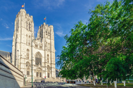 The Cathedral of St. Michael and St. Gudula medieval Roman Catholic cathedral Brabantine Gothic style building with bell towers and trees in park in Brussels city historical center, Belgiumの写真素材