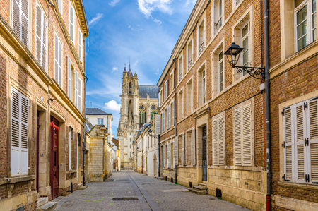 Narrow pedestrian street in old historical city center with cobblestone road, buildings shutter windows, Cathedral Basilica of Our Lady of Amiens Notre-Dame, typical old town view, Northern Franceの写真素材