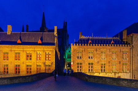 Blinde-Ezelbrug bridge across Groenerei Green Canal in Brugge old town, Stadhuis City Hall and Brugse Vrije Liberty of Bruges building in historical city centre, evening view, Flemish Region, Belgiumの写真素材