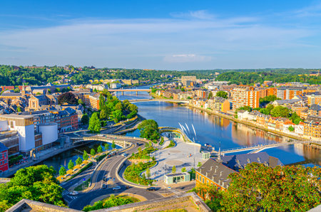 Namur cityscape with confluence of Sambre and Meuse rivers with bridges, aerial panoramic view of Namur city, skyline horizon with green forests trees on hills, Wallonia, Walloon Region, Belgiumの写真素材