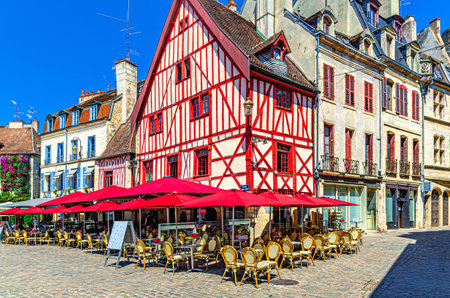 Street restaurant, cafe with tables and chairs and old typical houses colorful buildings in Dijon city historical center on cobblestone square, Dijon old town, Bourgogne-Franche-Comte region, Franceの写真素材