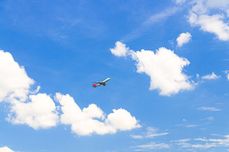 Airplane take off into a blue sky with white clouds, Passenger plane aircraft flying on blue sky backgroundの写真素材