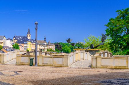 Fontaine aux colombes Fountain with dove of peace sculpture and small bridge in Judiciary Cite judiciaire Justice quarter in Ville Haute quarter with Luxembourg City historical center backgroundの写真素材