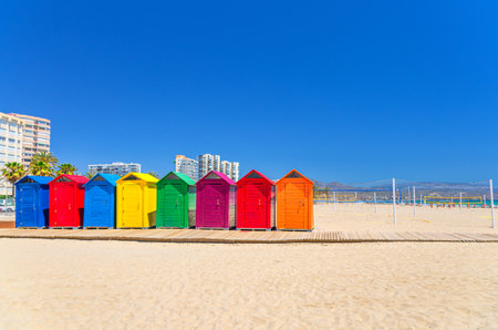 Playa de San Juan beach in Alicante city, wooden colorful storage huts sheds cabins for sports equipment on sandy beach of Mediterranean Sea coast Costa Blanca coastline in sunny summer day, Spainの写真素材