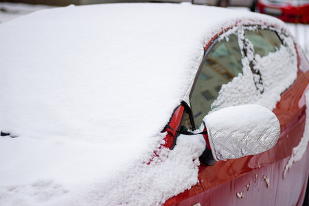 Close-up of a red car element covered in snow and iceの写真素材