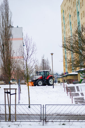 A tractor clears snow from snow-covered streets.