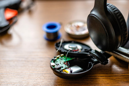 Disassembled Wireless Headphones with Exposed Circuit Board on Deskの写真素材