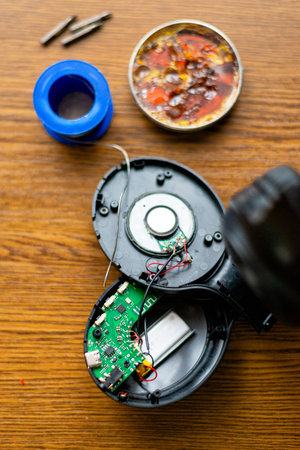 Opened Wireless Headphones with Internal Parts and Tools on Tableの写真素材