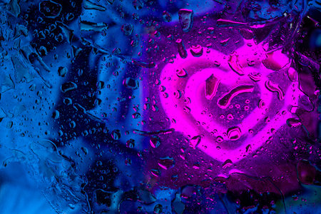 Creative glowing heart icon on a dark background with blue light streaks and organic textures for...