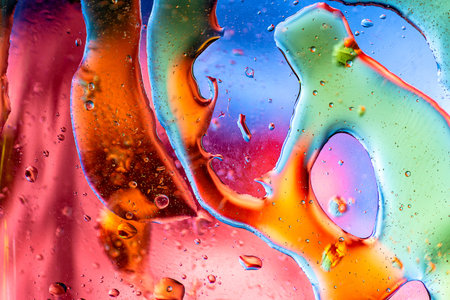 Vivid psychedelic pattern of multicolored oil smears and transparent water bubbles on a bright...