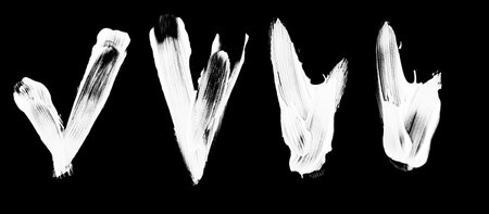 A collection of sketchy white chalk check marks and tick symbols hand drawn on a black chalkboard for success and approval concepts.の写真素材