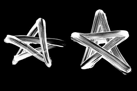 Collection of sketchy five-pointed stars hand drawn in white chalk on a black chalkboard for rating and success concepts.の写真素材