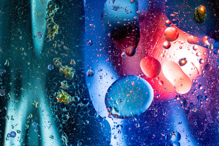Mesmerizing blue abstract macro featuring oil and water interaction with transparent spheres,...