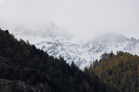 Snow-covered mountain peaks partially obscured by clouds.