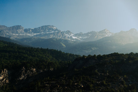Mountain range with snow-capped peaks under a clear blue sky.の写真素材