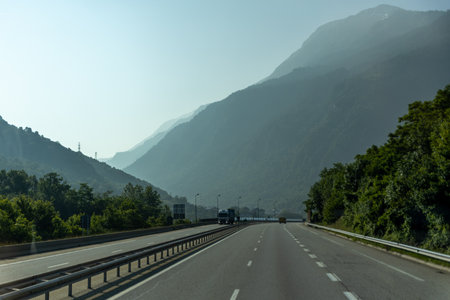 A scenic highway with mountains in the background under a clear sky.