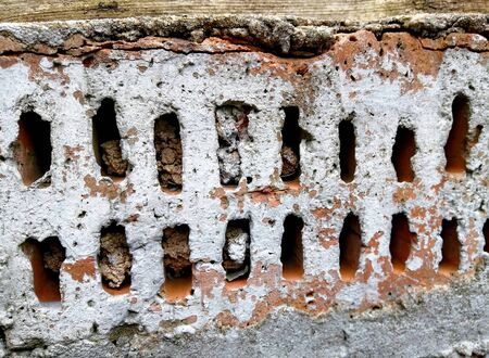 Plastered red brick with chipped pieces of mortar. Old textured very durable masonry of bricks....