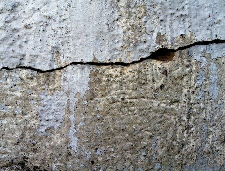 A gray wall with a deep crack across the entire surface. Photo background for projects and...