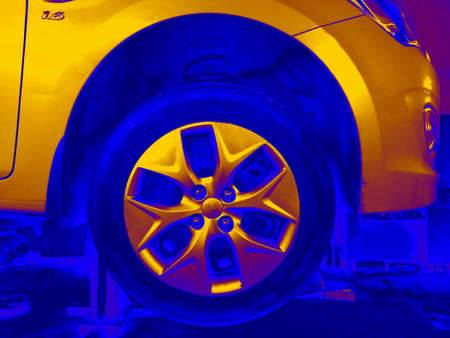 Art image of a car wheel and bumper in bright yellow and blue with neon effect.