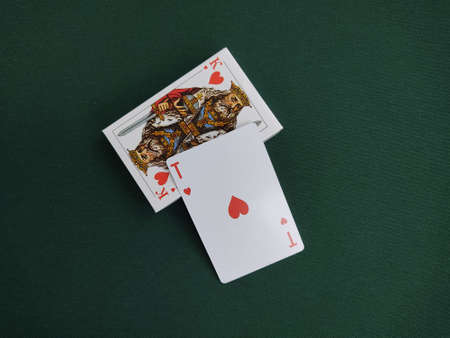 The ace of hearts card lies on a deck of playing cards with a king of hearts face picture. Cards on...