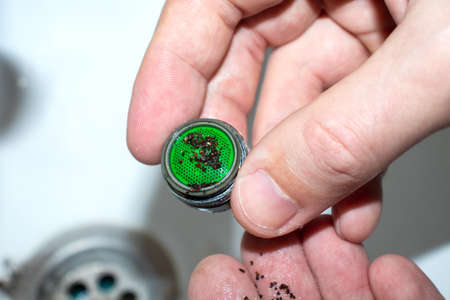 Plumber repairing the faucet of a sink. Plumbing repair concept. Cleaning the aerator on the mixer