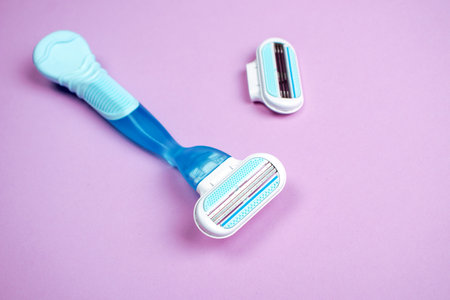Women razor with replaceable cartridge isolated on a pink background. Close-up. Beauty concept