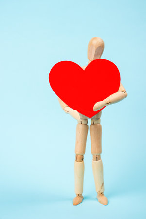 Mannequin man holding a red heart. Love symbol. Happy Valentine's Day Greeting Card, Mother's Day, Birthdayの写真素材