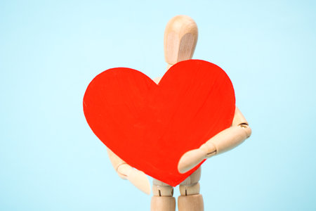 Mannequin man holding a red heart. Love symbol. Happy Valentine's Day Greeting Card, Mother's Day, Birthdayの写真素材
