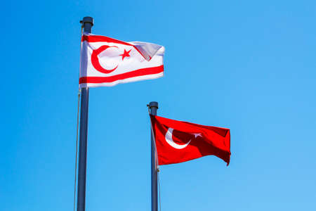 Turkey and North Cyprus flags on blue sky backgroundの写真素材