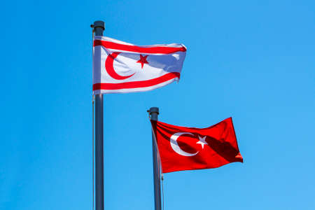 Turkish and North Cyprus flags on blue sky backgroundの写真素材