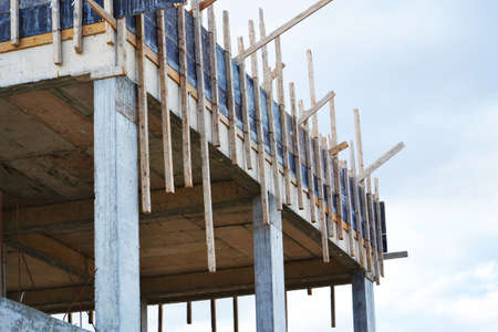 Unfinished building made of concrete slabs, reinforcing bars and wooden planksの写真素材