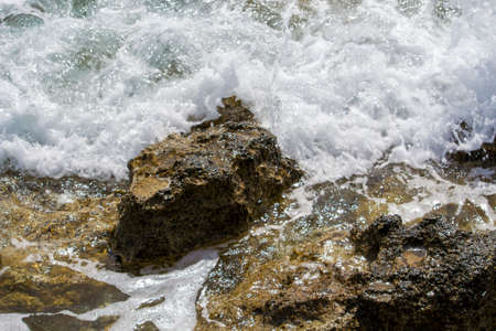 Splashes of waves crashing on rocks.の写真素材
