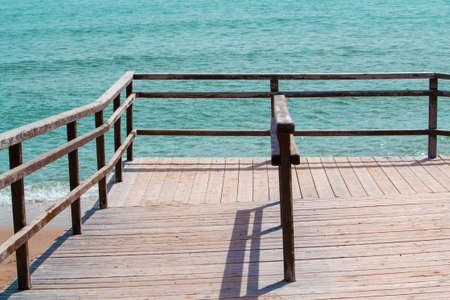 Wooden path to the sand beach. Beautiful ocean on backgroundの写真素材