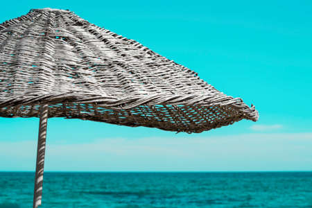 Straw umbrella on the sand beach near the seaの写真素材
