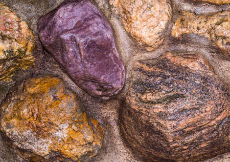 Decorative wall of large stones. Concreted stones. Pebbles in the wall. A garden wall. Decorative surface. Decorative stone wall of the large colored cement bonded stonesの写真素材