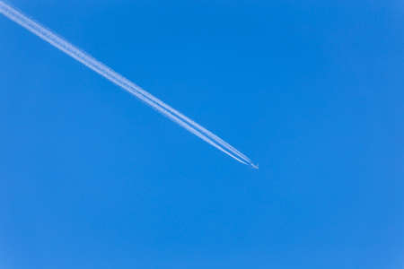 Jet. Inversion trace of the aircraft. Blue sky. The vanishing trace of the planeの写真素材