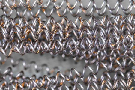 Steel spring. Iron wire with traces of rust. Technological background.の写真素材