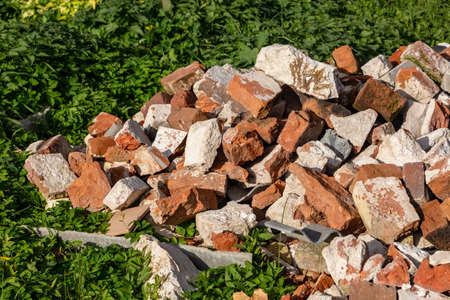 Broken red brick. Construction waste. Pieces of broken bricks.