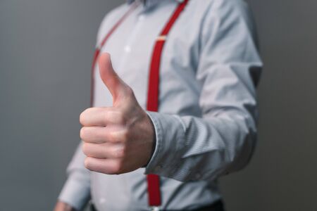 Businessman motivates an employee with thumb up gestureの写真素材