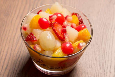 Bowl of healthy fresh fruit salad on wooden backgroundの写真素材
