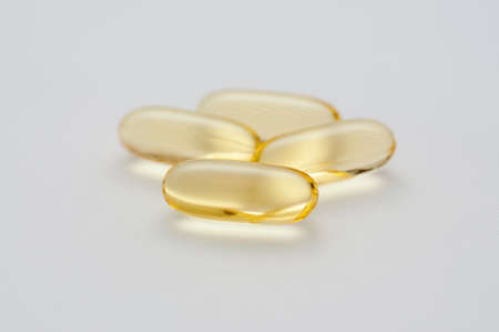 gelatine capsules of omega 3 fish oil on white backgroundの写真素材
