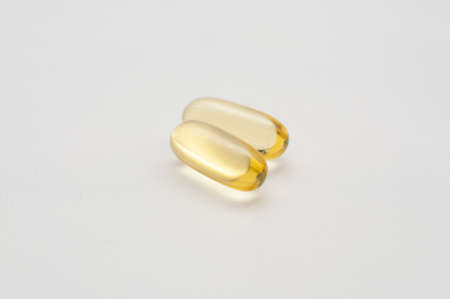 gelatine capsules of omega 3 fish oil on white backgroundの写真素材