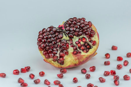 Ripe pomegranate with seeds on a white background.の写真素材
