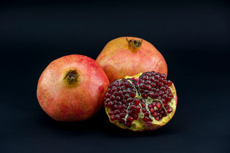 Ripe pomegranate fruit on a black background close upの写真素材