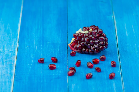 Pomegranate on a blue wooden background. pomegranate seedsの写真素材